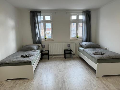 two beds in a room with two windows at Monteurzimmer Renix Heilbronn in Brackenheim