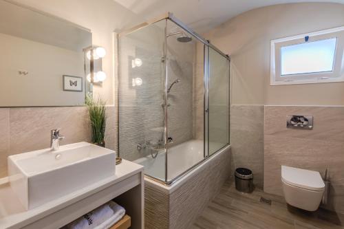 un bagno con doccia, lavandino e WC di Rivazzurra Beachfront Luxury Villa a Lithakia