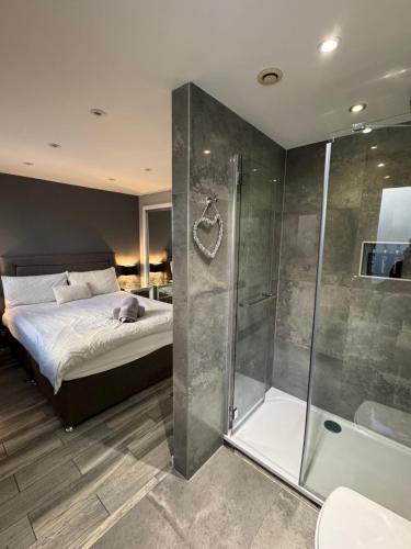 een slaapkamer met een bed en een glazen douche bij KM Granton Apartment in Edinburgh