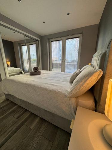 a bedroom with a large bed with a large window at KM Granton Apartment in Edinburgh
