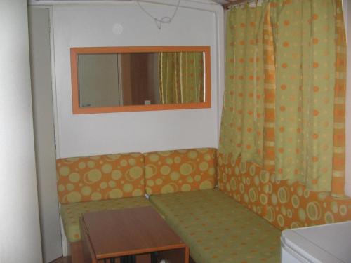 Habitación pequeña con sofá y ventana en Camping Helios Triscina, en Triscina