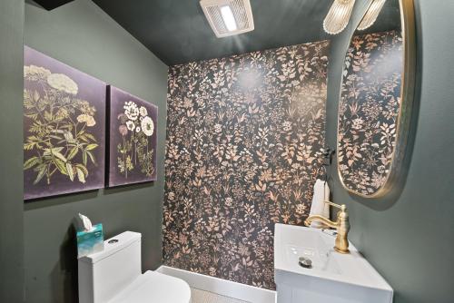 a bathroom with a toilet and a sink and a mirror at The Pink House in Banner Elk