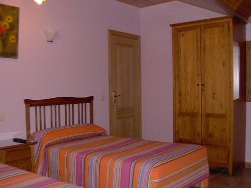 a bedroom with a bed and a wooden cabinet at Villa de La Yunta in La Yunta