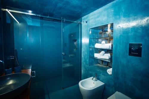 a blue bathroom with a sink and a shower at Il cortile di Elen in Marsala