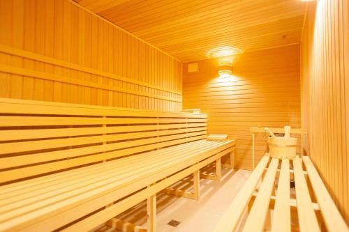 a sauna with a wooden bench in a room at Ostseehotel Warnemünde in Warnemünde
