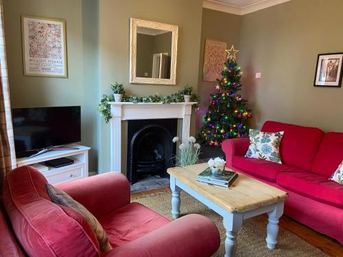 a living room with a christmas tree and red couches at The City Pad in Norwich