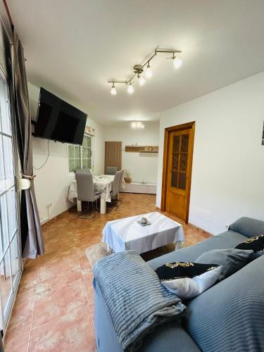 a living room with a couch and a tv at Casa Sol y Calma in Cómpeta