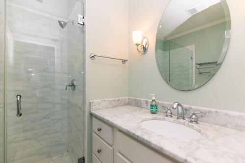 a bathroom with a sink and a shower with a mirror at Creekside Cottage in Edisto Island