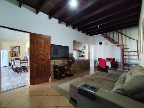 圣塞巴斯蒂安Sobrado em São Sebastião的带沙发和电视的客厅以及用餐室。