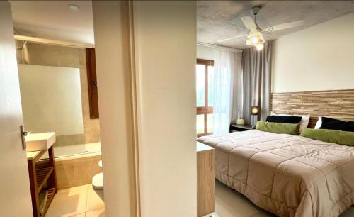 a hotel room with a bed and a bathroom at Btwins Pinamar in Pinamar