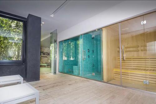 a bathroom with a shower with a glass wall at Btwins Pinamar in Pinamar