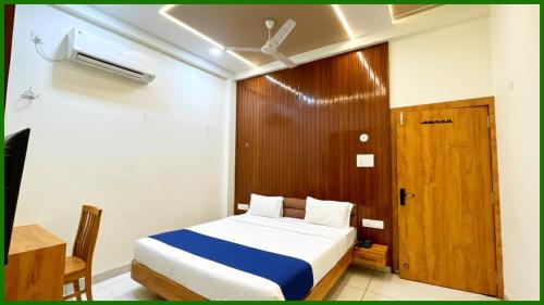 Un dormitorio con una cama y una puerta de madera. en Near Mahakal Temple G- Residency Near Railway Station - Air Conditioned hotel at Prime Location - Lift and Parking - BEST HOTEL IN UJJAIN, en Ujjain