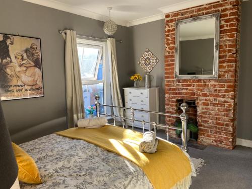 a bedroom with a bed and a brick fireplace at The City Pad in Norwich