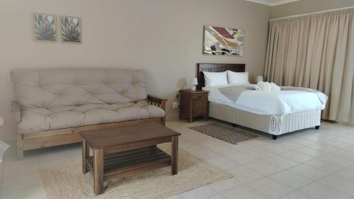 a bedroom with a bed and a couch at Mthontsi Lodge in Kroomie