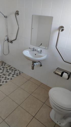 a bathroom with a white toilet and a sink at Mthontsi Lodge in Kroomie