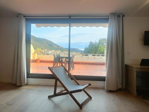 帕劳·萨巴尔德拉Sunny Relaxing Penthouse Costa Brava, Sea & Mountain Views, Huge Terrace, Fiber 1GB的坐在大窗户前的椅子