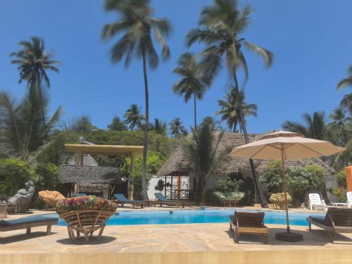米查维Sunset Mkuu Boutique Hotel的一个带椅子和遮阳伞的游泳池,并种植了棕榈树