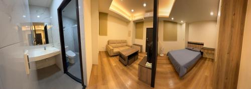 ein Badezimmer mit einem Bett und einem Waschbecken in einem Zimmer in der Unterkunft 東印象 in Hsin-kuang