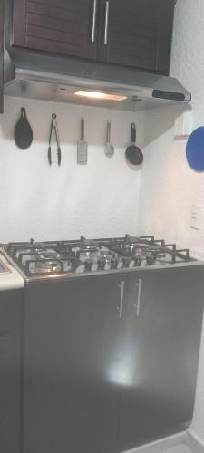 a stove top in a kitchen with utensils on the wall at Cuarto 1 in Cuautitlán Izcalli