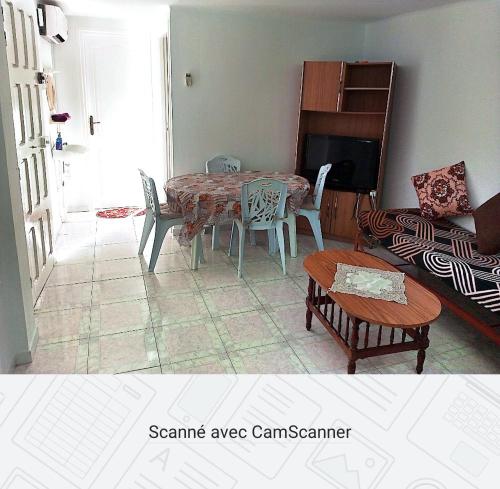 a living room with a table and chairs and a couch at Studio AMINE in Mahdia