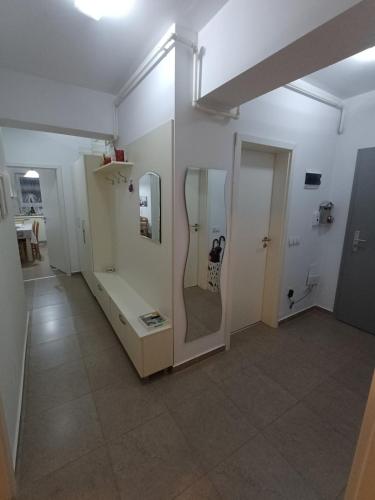 a room with a bathroom with a mirror and a hallway at Favorite Apartmet in Braşov
