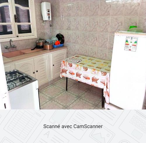 een keuken met een koelkast en een tafel. bij Studio AMINE in Mahdia