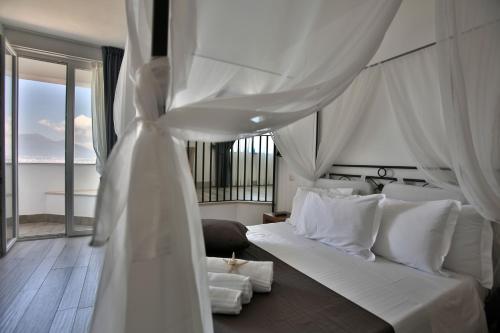 a bedroom with a white bed with a white drape at Relais Manfredi in Castellammare di Stabia