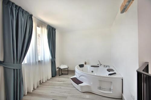 a bathroom with a white tub and a window at Relais Manfredi in Castellammare di Stabia