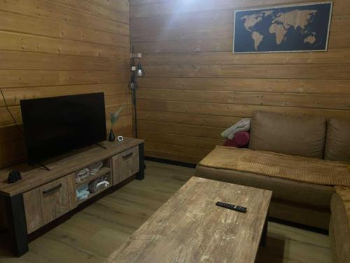 a living room with a couch and a flat screen tv at Le Havre de Bois in Bourbourg