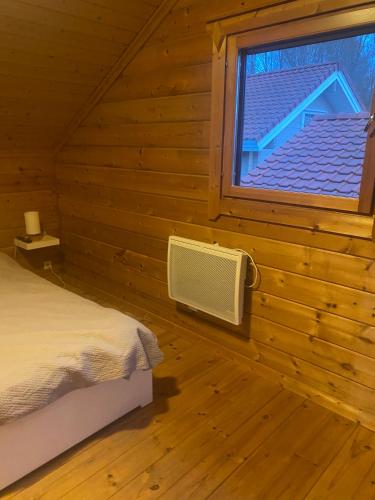 a bedroom with a window in a log cabin at Le Havre de Bois in Bourbourg