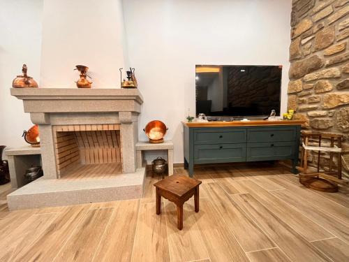 a living room with a fireplace and a television at Casa d'Abó Anica in Miranda do Douro