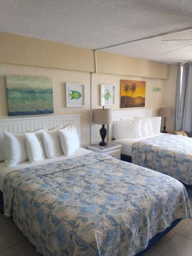 a hotel room with two beds with white pillows at Oceanfront on Daytona Beach in Daytona Beach Shores