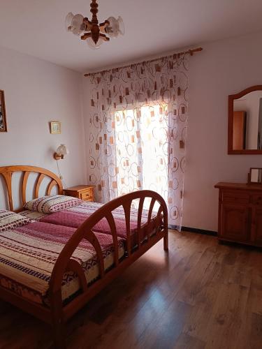a bedroom with a wooden bed and a window at Burriana in Burriana