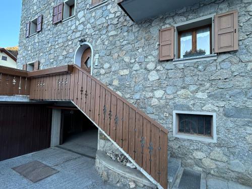 a stone building with a wooden ramp leading up to a house at Casa dei cugini in Oga