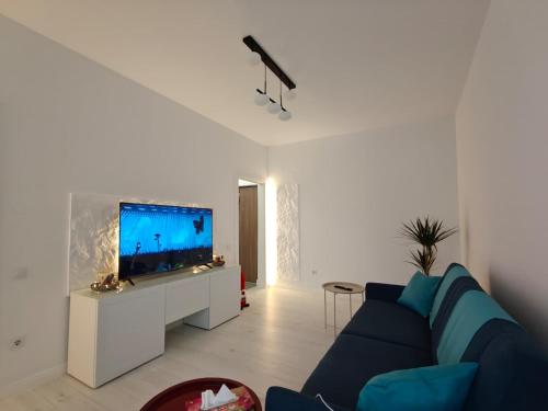 een woonkamer met een blauwe bank en een flatscreen-tv bij Home Ready in Sibiu