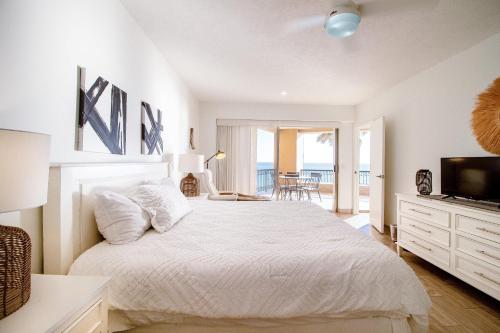 una camera da letto bianca con un letto e una televisione di Sonoran Spa E301 a Campo del Medio