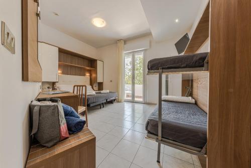 a room with two bunk beds and a kitchen at Hotel Stacchini in Cesenatico