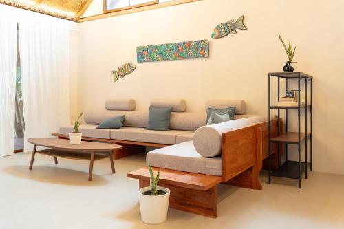 una sala de estar con un sofá y una mesa en Beachfront Katutubo Villa - where the world ends, en El Nido