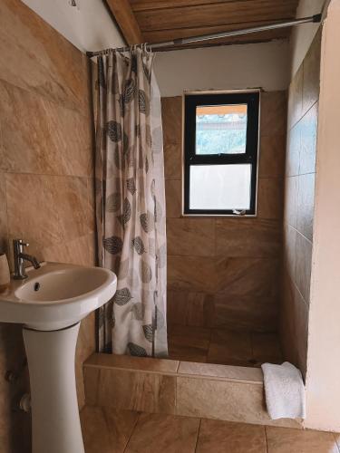 a bathroom with a shower and a sink and a window at Mama Raywa in Chavín de Huantar