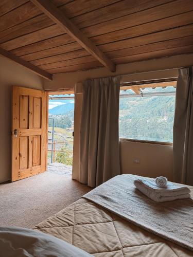 a bedroom with a bed and a large window at Mama Raywa in Chavín de Huantar