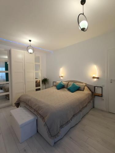 a bedroom with a large bed and two lights at Home Ready in Sibiu