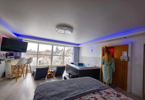a woman standing in a bedroom with a bed at Wellness pod zvezdami, Maribor - PRIVATE in Maribor