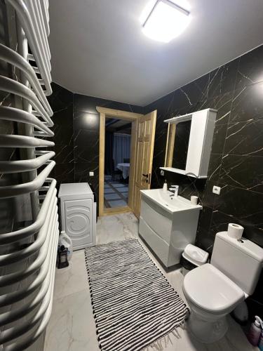 a bathroom with a white toilet and a sink at Фазенда in Vorokhta