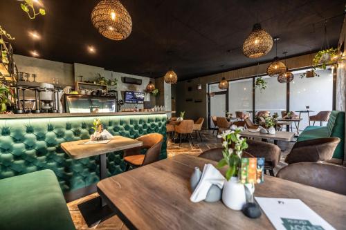 a restaurant with wooden tables and green seats at G&T Square Apartments in Liptovský Mikuláš