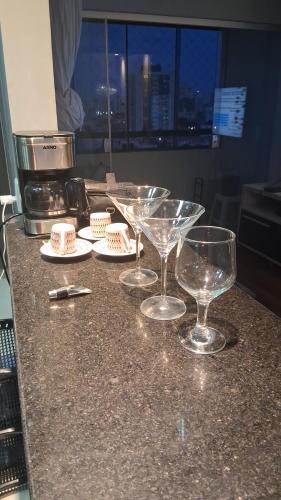 un gruppo di bicchieri da vino seduti su un bancone di Dois Quartos Completo a Vila Velha