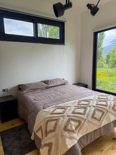 a bedroom with a large bed with a window at Refugio Nauru in Puerto Dunn