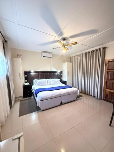 a bedroom with a bed and a ceiling fan at Villa Thabiso in Bulawayo