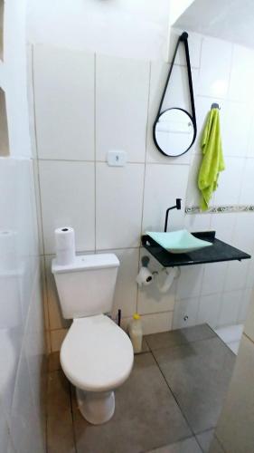 a bathroom with a white toilet and a sink at Loft Centro in Aparecida