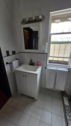 un bagno bianco con lavandino e specchio di Luxury Suites Tokio a 100 mts del consulado a Manuel F. Martínez