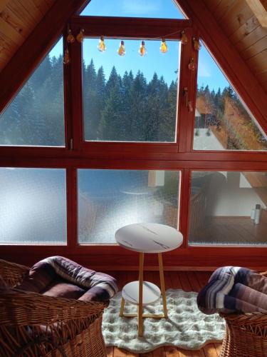 een kamer met een groot raam met een tafel en stoelen bij Vikendica in Vlasic